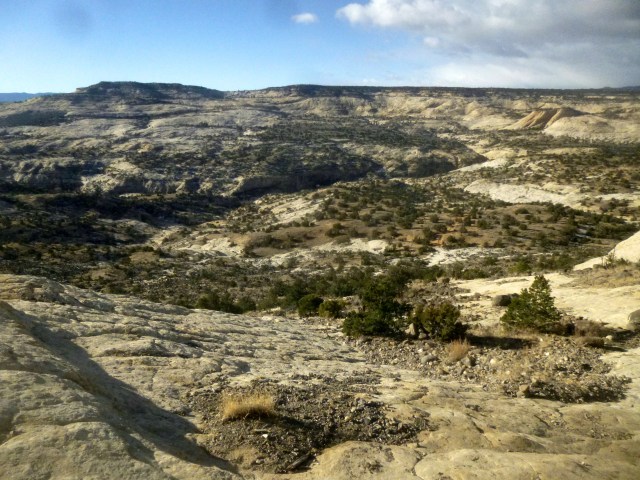 View of Upper Calf Creek Canyon and McGath Point (6,759') from the canyon rim. The sandy trail can be seen near the center right of the photo.