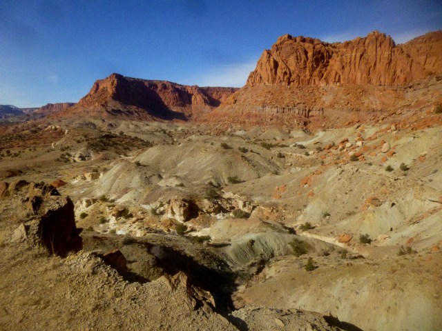 Chinle badlands, with Wingate sandstone cliffs beyond